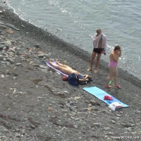 Naked babe tanning in front of a couple