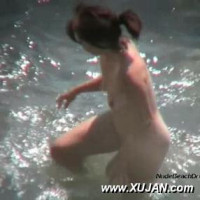 Hot brunette gets wet before jumping into the water