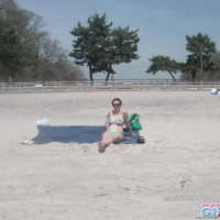 Busty brunette takes sunbath on public beach
