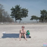 Busty brunette takes sunbath on public beach