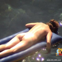 Mature brunette takes a long relaxing swim naked