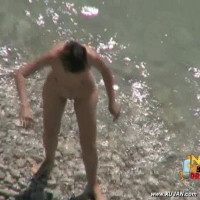 Hot brunette filmed while naked getting by the sea