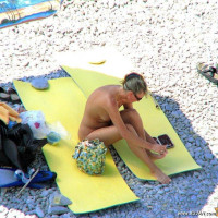 Mature blonde sitting topless in the shade