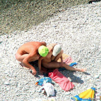 Mature blonde sitting topless in the shade
