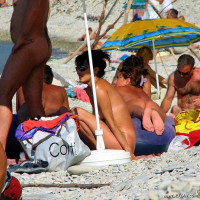 Mature blonde sitting topless in the shade