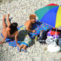 Mature blonde sitting topless in the shade