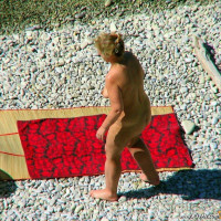 Mature blonde sitting topless in the shade