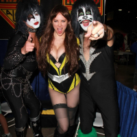 Busty Maitland Ward wearing latex bodysuit fishnets and boots at the Long Beach