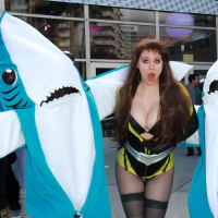 Busty Maitland Ward wearing latex bodysuit fishnets and boots at the Long Beach