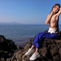 Petite Leona Mia gets naked on the rocky beach
