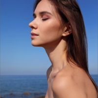 Petite Leona Mia gets naked on the rocky beach