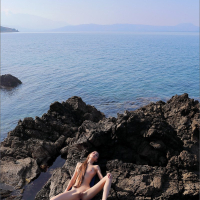 Petite Leona Mia gets naked on the rocky beach