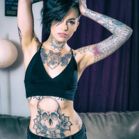 Leigh Raven exposes her inked body in the living room