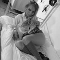 Hayley Marie Coppin takes off her plaid skirt while posing in the bedroom