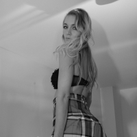 Hayley Marie Coppin takes off her plaid skirt while posing in the bedroom