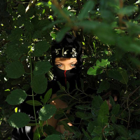 Ninja attired babe Shione Cooper freeing large natural tits in the forest
