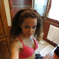 Curlyhaired latina slipping off her pink lingerie and making selfies