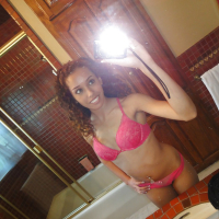 Curlyhaired latina slipping off her pink lingerie and making selfies