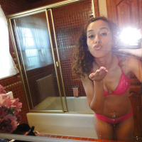 Curlyhaired latina slipping off her pink lingerie and making selfies