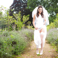 Newly married bride Carolina Abril posing outdoors in wedding dress