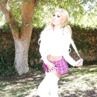 Platinum blonde babe Carmen Caliente modeling topless outdoors in skirt