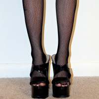 Avery spreads her ass and pussy for the camera wearing black fishnet stockings