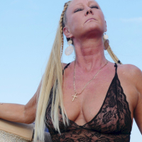 Stunning blonde Natalie K posing in a black outfit outdoors