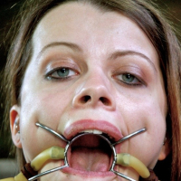 Nadia White is bound with tits exposed and mouth spread wide