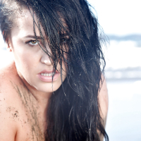 Chesty brunette pornstar Leanne Crow exposing huge hooters on the beach
