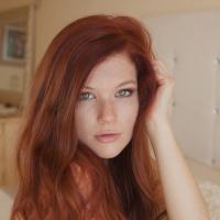 Redhead beauty Mia Sollis strips on the bed baring her pink pussy