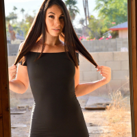 Ashley Wolf poses in a tight dress on a motorcycle