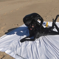 Kinky Latex Lara gets talked into jerking off a dick on the beach