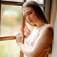 Beautiful girl Izzy Lush gets naked while posing by the window