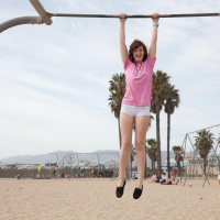 Redhead coed Ellena Woods invites you to have some fun with her on the beach