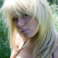 Beautiful blonde Madden in blue posing on a motorcycle
