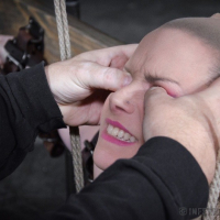 Bella Rossi is bound in wood with mouth spreader with clamps on her big tits