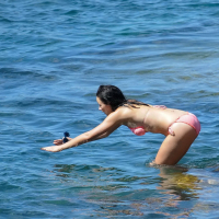 Demi Harman showing off her curvy body in a striped red bikini at the beach in S