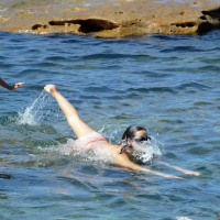 Demi Harman showing off her curvy body in a striped red bikini at the beach in S