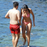 Demi Harman showing off her curvy body in a striped red bikini at the beach in S