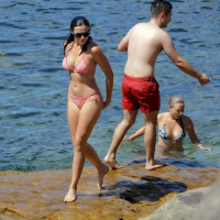 Demi Harman showing off her curvy body in a striped red bikini at the beach in S