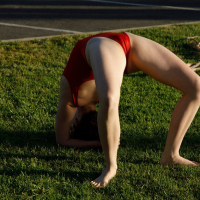 Kayla Coyote performs gymnastics in a red bodysuit