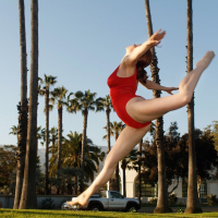 Kayla Coyote performs gymnastics in a red bodysuit