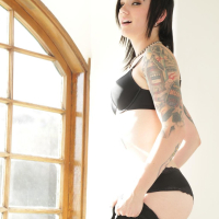 Inked Nikki Hearts fingers herself by a Window