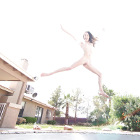 Leggy solo girl Lola Hunter poses outdoors beside swimming pool in bikini