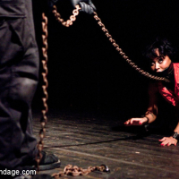 Mia has been left in a dark dungeon chained to the floor She is crotched away