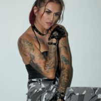 Foxy redhead shows her tattoos while posing for the camera