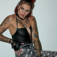Foxy redhead shows her tattoos while posing for the camera