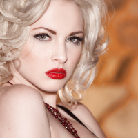 Glamorous platinum blonde with pale skin slipping off her lingerie