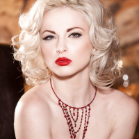 Glamorous platinum blonde with pale skin slipping off her lingerie
