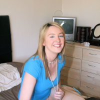 Sexy looking babe posing in panties and blue shirt in the bedroom